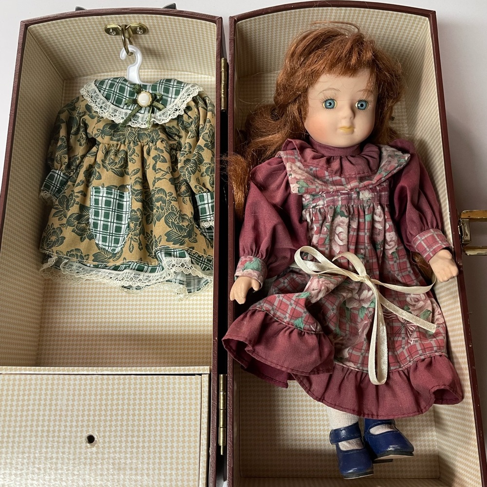 Porcelian faced doll with dresses , trunk , hangers .